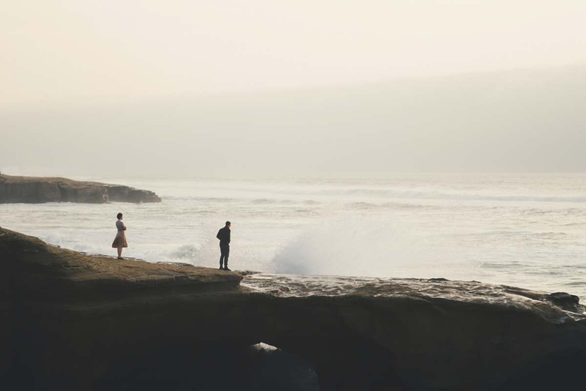san diego 2 person standing on rock near sea during daytime ocean beach